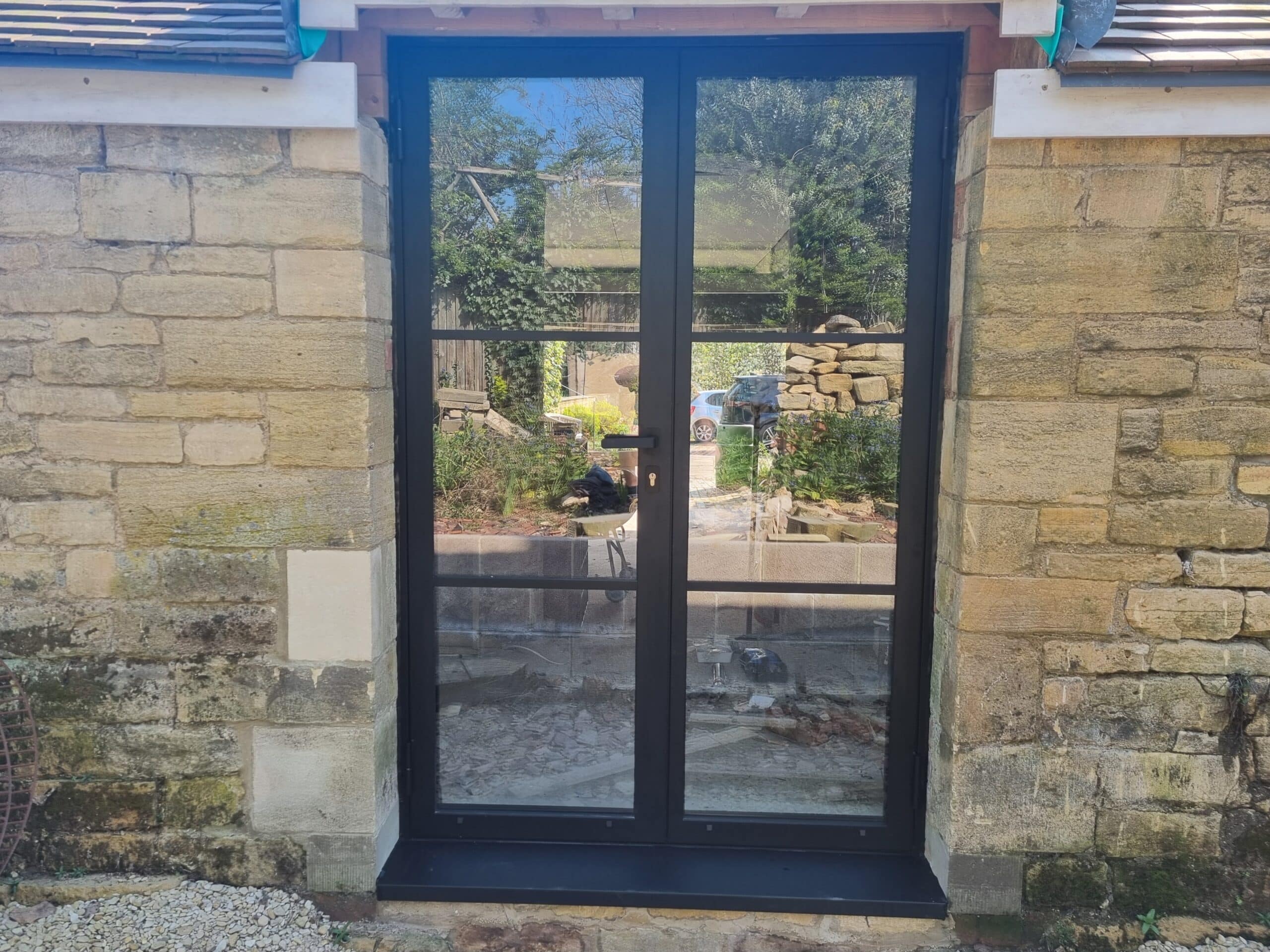 Replace an outdated rear access with something more modern, stylish, and light-enhancing. Our solution was a set of steel exterior double doors, finished in a textured black powder coat and paired with coordinating black hardware for a clean, contemporary look.